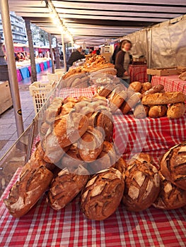 Bread sold at Street market in Paris. People walking and buying food