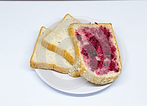 Bread with spread jam on the dish on white isolate background