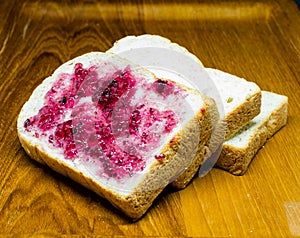Bread with spread jam on the wooden dish