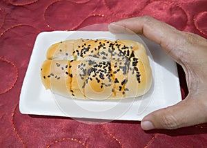 Bread sprinkled with chocolate sprinkles in a white container with a red background