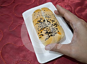 Bread sprinkled with chocolate sprinkles in a white container with a red background