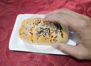 Bread sprinkled with chocolate sprinkles in a white container with a red background