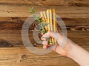 Bread Sticks in Hand, Salted Breadstick, Crispy Grissini, Dry Homemade Pretzels, Bread Stick on Wooden Background