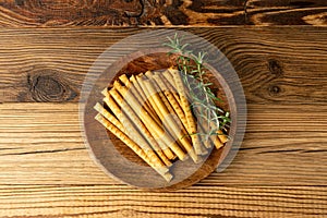 Bread Sticks on Wood Plate, Salted Breadstick, Crispy Grissini, Dry Homemade Pretzel on Wooden Background