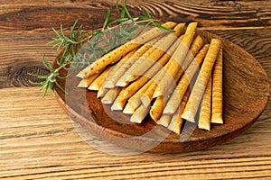 Bread Sticks on Wood Plate, Salted Breadstick, Crispy Grissini, Dry Homemade Pretzel on Wooden Background