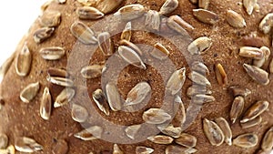 Bread with sunflower seeds, rotates counterclockwise, turning, top view, close up.