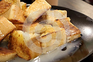 Bread toast with butter and condensed milk in a plate, select focus