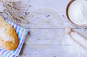 Bread with wheat ears and bowl of flour