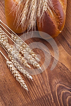 Bread and wheat ears on old wooden boards