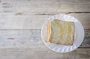 Bread in white dish put on wooden desk.