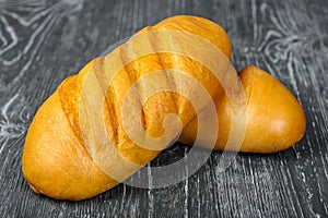 Bread white loaf of wheat flour with incisions on a wooden background