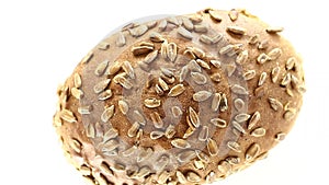 Bread whole with sunflower seeds, rotates counterclockwise, turning, top view, close up.