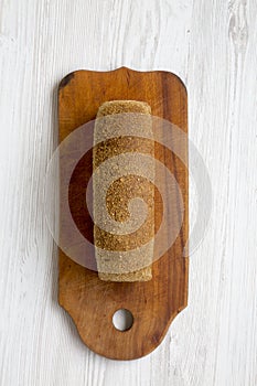 Bread on wooden cutting board on white woodem background.