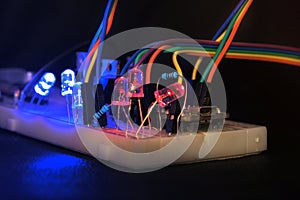 Breadboard arduino nano prototyping board transistors resistors LEDs red and blue in glow in the dark on black skin