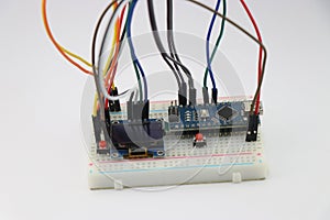 Breadboard circuit made from display module and microcontroller board connected with wires shows concept of innovative stem