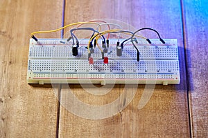 Breadboard with electrical elements, on a wooden table