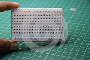 Breadboard which is used in solderless prototyping of various electronic projects held in hand