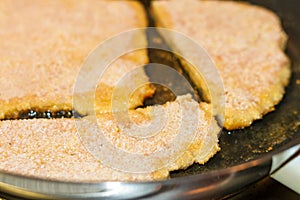 Breadcrumb coated food in frying pan