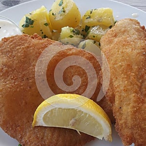 breadcrumbed and fried veal scallop with potatoes