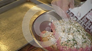 Breadcrumbs being added to bowl of ground beef