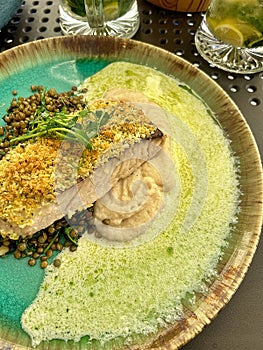 breaded cod fillet, crispy breadcrumbs on fish fillet, lentils, celery puree, dinner in a restaurant