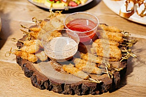 Crispy fried skewers with dipping sauces photo