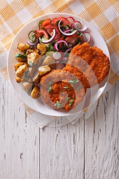 Breaded German Weiner schnitzel with potatoes. vertical top view