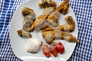 Breaded kid ribs, tomato and artichokes