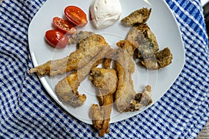 Breaded kid ribs, tomato and artichokes