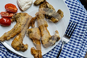 Breaded kid ribs, tomato and artichokes