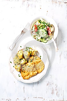 Breaded pork cutlet with baked potatoes and salad; Polish cuisine