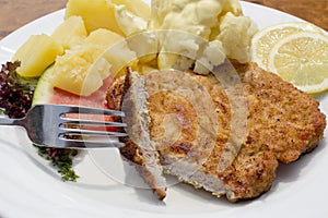 Breaded pork cutlet with boiled potatoes, cauliflower and hollandaise sauce