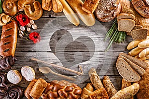 Breads, pastries, christmas cake on wooden background with heart, picture for bakery or shop, valentines day