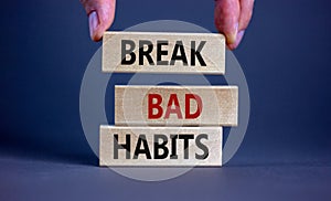 Break bad habits symbol. Wooden blocks with words `break bad habits`. Male hand. Beautiful grey background, copy space. Business