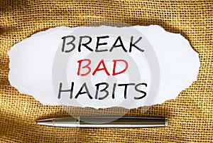 Break bad habits symbol. Words `Break bad habits` on white paper. Black metallic pen. Beautiful canvas background. Business,