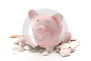 Break the bank, economic downturn and bankruptcy concept theme with a broken piggy bank and scattered coins isolated on white