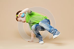 break dance kids. little break dancer showing his skills in dance studio. Hip hop dancer boy performing over studio background