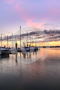 Break of dawn sunrise over boats and sailboats at Factory Bay marina in Marco Island