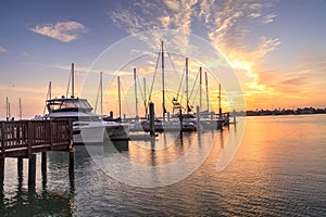 Break of dawn sunrise over boats and sailboats at Factory Bay marina in Marco Island