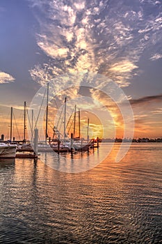 Break of dawn sunrise over boats and sailboats at Factory Bay marina in Marco Island