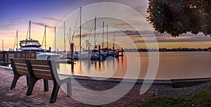 Break of dawn sunrise over boats and sailboats at Factory Bay marina in Marco Island