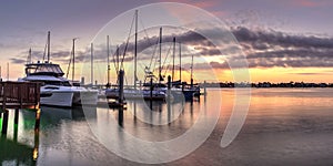 Break of dawn sunrise over boats and sailboats at Factory Bay marina in Marco Island