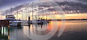 Break of dawn sunrise over boats and sailboats at Factory Bay marina in Marco Island