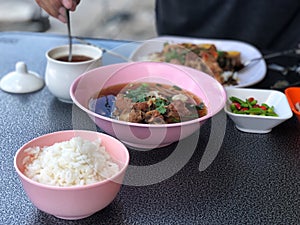 Break fast with Pork Clear Soup in pink bowl and rice in pink cup, delicious of  Thai food