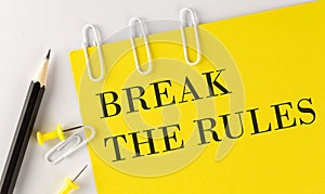 BREAK THE RULES word on the yellow paper with office tools on white background