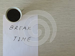 Break Time Concept. Relaxation. Office desk table with break time note and coffee cup. Top view.