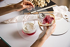 Break to eat. Pleasant and tasty moment of relaxation and tasting. Table with a glass of strawberry and yogurt gelatin