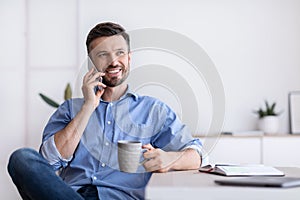Break At Work. Relaxed Office Employee Talking On Cellphone And Drinking Coffee