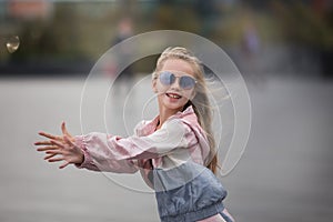 Breakdance little girl. Sport little girl in fashion sportswear doing fitness exercise in the street, outdoor sports, urban style