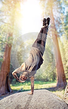 Breakdance performer, upside down motion in forest